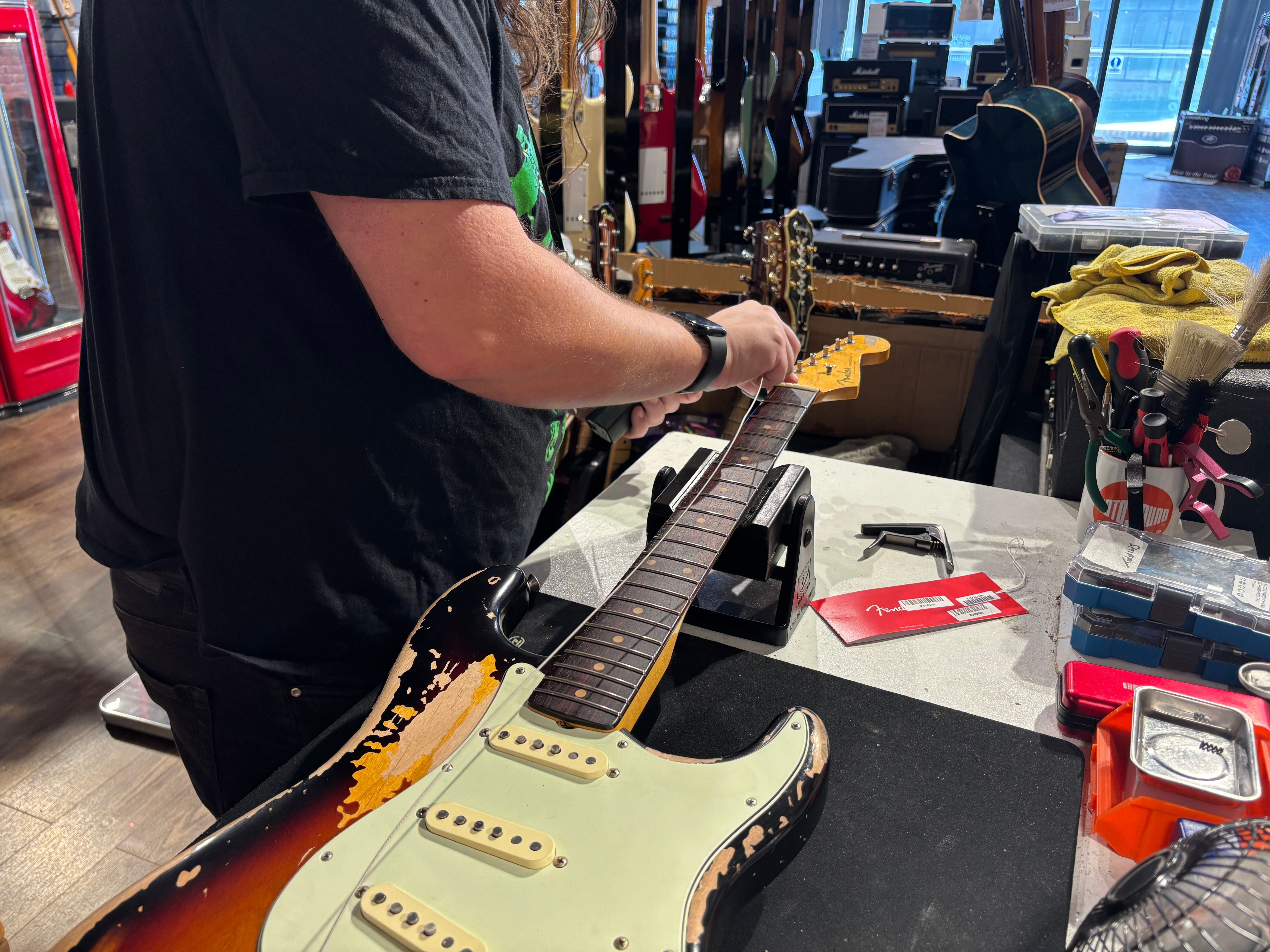 Guitar tech changes strings on Stratocaster 