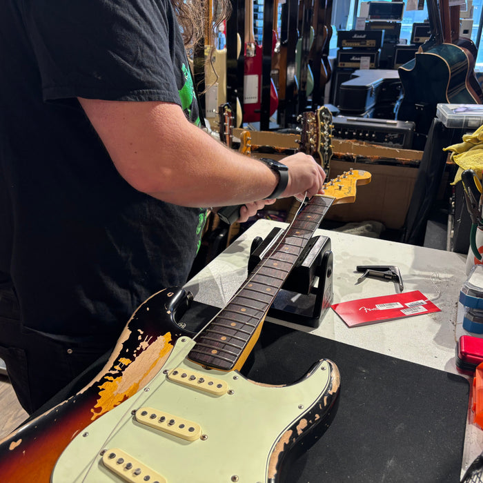 Guitar tech changes strings on Stratocaster 
